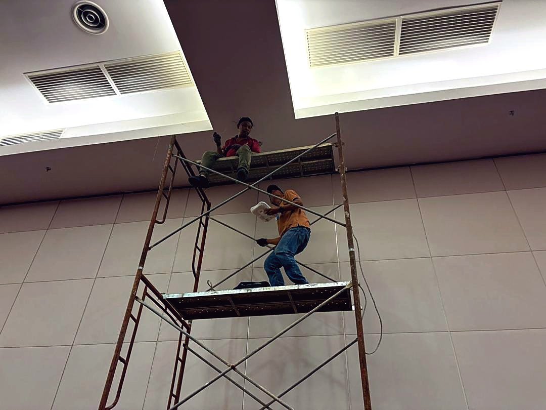 Technicians installing access points in a hotel function hall